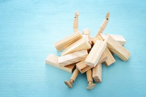 Wooden,Dummy,Buried,Under,Stack,Of,Domino,Blocks,Asking,For